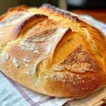 Rustic homemade bread with a crisp crust on a kitchen counter.